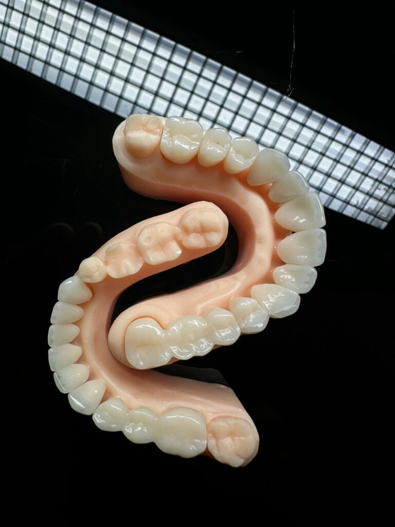Close-up view of a dental mold showcasing teeth arrangement on a black backdrop.